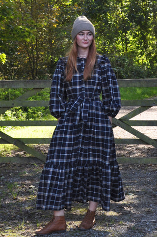 woman stood by gate wearing dress