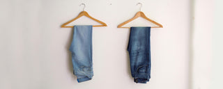 denim jeans on coat hangers on the wall