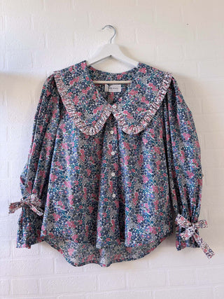 mixed floral blouse on hanger