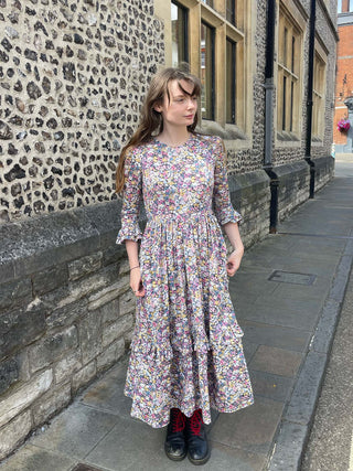 women wearing floral print midi dress by wall
