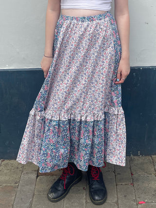 women wearing mixed print skirt by wall