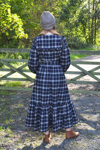 woman stood by gate wearing dress back view