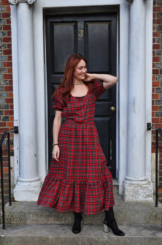 women wearing red check skirt by door