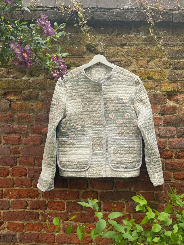 The Well Worn quilted jacket hanging on brick wall
